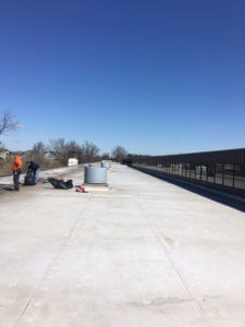 workers repairing flat roof of large building