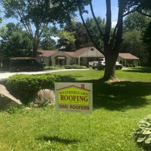 weatherguard roofing sign in large front yard
