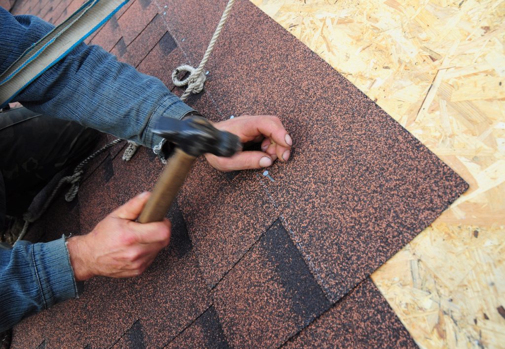 Roofer installing asphalt roof shingles